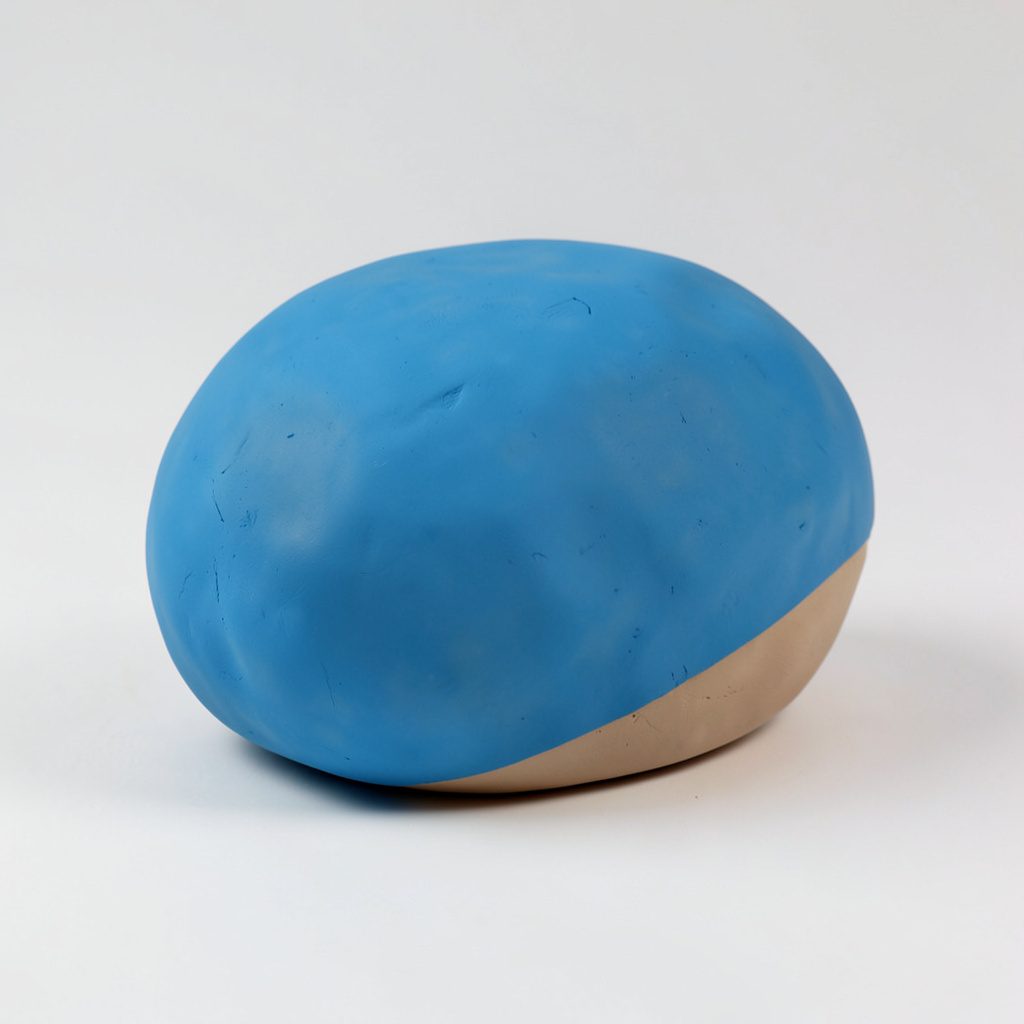 Rounded clay-style photo booth corner with soft pastel walls and warm ambient lighting inside a selfie museum